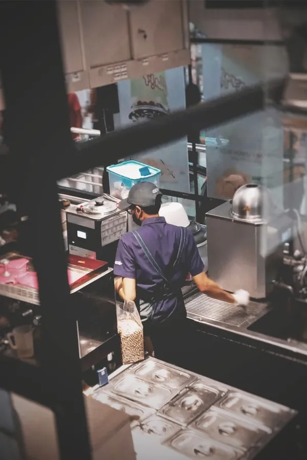 A man working in a commercial kitchen preparing food